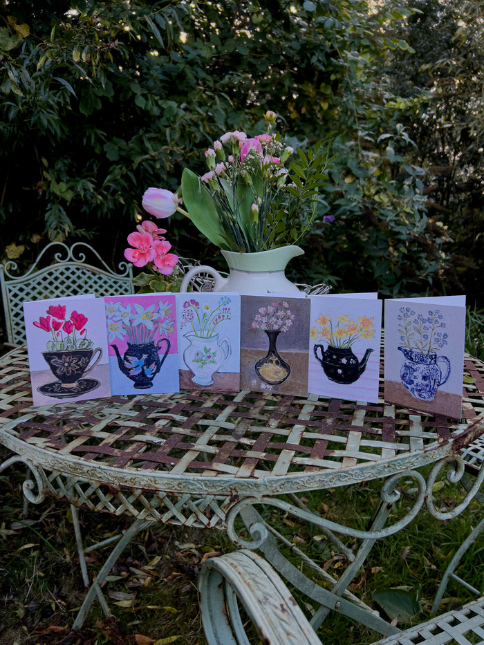 Set of art  greeting cards with floral designs on a garden table by Zoe Attwood.