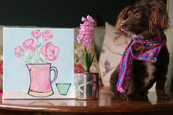 Original painting of pink peonies in a vintage Sunderland jug on canvas by Zoe Attwood with Bertie the brown studio dog in a scarf. 